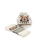 Niddynoddy white linen bread basket and two kitchen towels set with colorful floral embroidery and fringed edges.